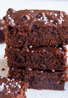 three chocolate brownies stacked on top of each other with white sprinkles