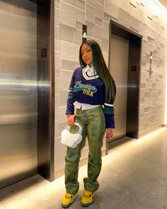 a woman with long hair standing in front of an elevator holding a white bag and wearing yellow shoes