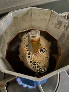 a metal container filled with liquid on top of a stove