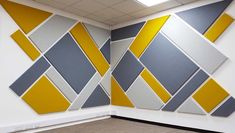 an empty room with yellow, grey and white squares on the wall