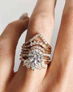 a woman's hand with three different rings on top of her finger and the other ring