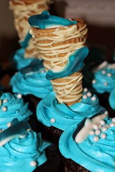 cupcakes with blue frosting and white decorations