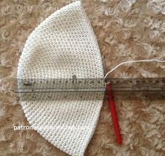 a crocheted hat with a measuring tape next to it