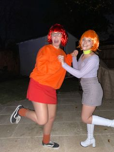 two women dressed in costumes posing for the camera