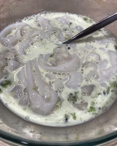 a bowl filled with soup and broccoli on top of a table