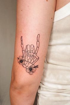 a woman's arm with a tattoo on it that has flowers in the middle