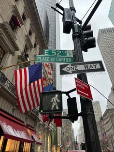 the street signs are clearly visible for all to see on this busy city street in new york