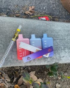 three different colored bottles are on the ground next to a chain and a bottle opener