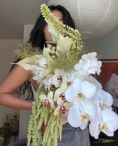 a woman holding a bouquet of flowers in her hands