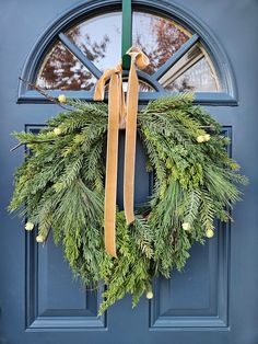 a wreath hanging on the front door of a house