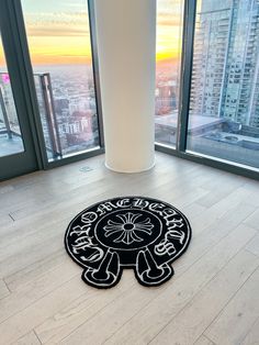 a black and white rug on the floor in front of large windows with city view