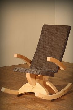 a wooden rocking chair sitting on top of a hard wood floor