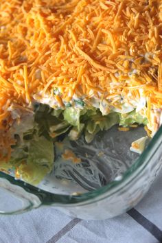 a casserole dish with shredded cheese and lettuce