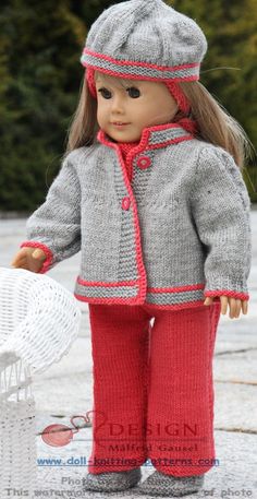 the doll is wearing a knitted coat and pants with red trims on it