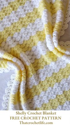 a yellow and white crocheted blanket on top of a bed