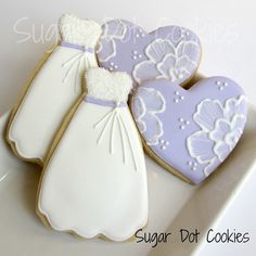 two decorated cookies in the shape of wedding gowns