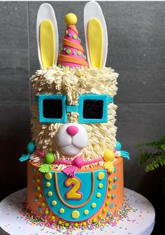 a birthday cake with a llama wearing sunglasses and a party hat on it's head