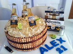 a cake that is sitting on top of a table with bottles of alcohol in it