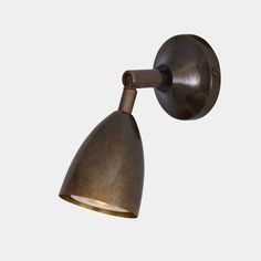 an old fashioned wall light with a metal shade on the side and a white background