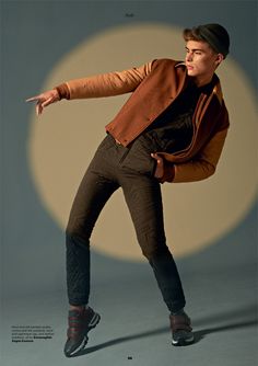 a man in brown jacket and black pants doing a trick with his arms stretched out