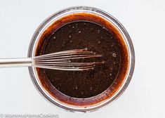 chocolate cake batter in a glass bowl with whisk