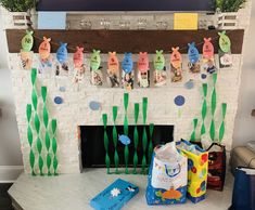 the fireplace is decorated with paper fish and seaweed garlands, along with other decorations