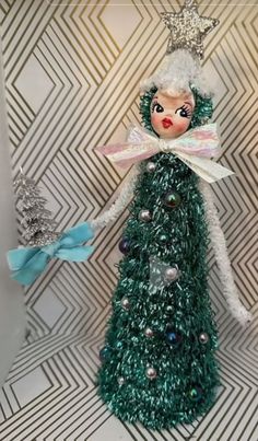 a green christmas tree ornament with a blue bow