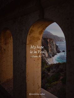 an arch with the words, my hope is in you written on it and overlooking the ocean