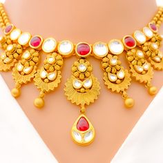 Make a statement with our Vibrant Antique Hanging Flower Necklace Set, crafted with 22k gold weighing 68.8 grams and featuring stunning Kundan stones. This antique finished necklace boasts a set length of 16.5" with 0.8" adjustable links and a secure hook lock. The striking hanging flower pendant has a drop length of 2", adding a touch of glamour to any ensemble. The set also includes matching earrings, 1.5" in length with screw backs. Elevate your style with this eye-catching piece, finished wi 22k Gold Necklace Set, 22k Gold Necklace, Hanging Flower, Gold Necklace Set, Antique Finish, Flower Pendant, 22k Gold, Flower Necklace, Matching Earrings