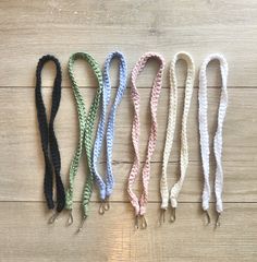 four different colored lanyards on a wooden surface