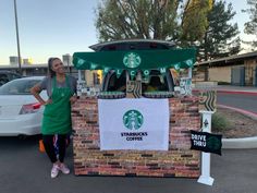 a woman standing in front of a starbucks coffee stand with her hands on her hips