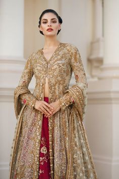 a woman in a gold and red outfit standing with her hands on her hips,