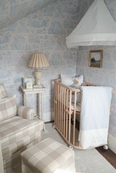 a baby's crib in a room with blue and white wallpaper on the walls