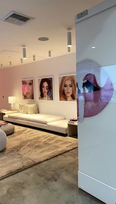 a living room filled with furniture and pictures on the wall next to a white couch