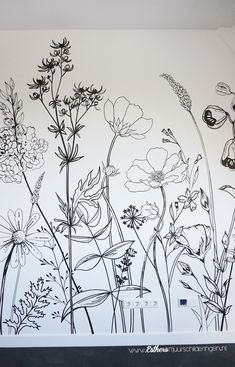 a drawing of wildflowers on a white wall with black and white lines in the background