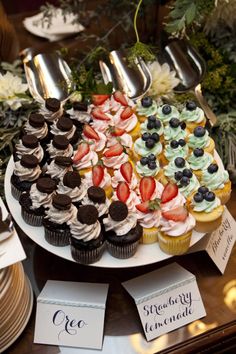 an assortment of cupcakes and desserts on a platter at a wedding reception