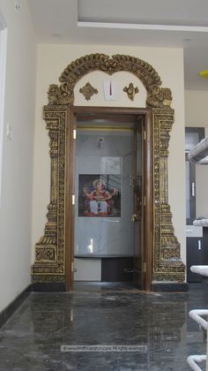 an ornate gold framed mirror in the entry way to a house with marble floors and walls