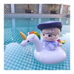 an inflatable pool float with a doll riding on the back of it, next to a swimming pool