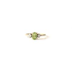 A stunning 9ct gold Peridot ring. This classic ring features a pale hued green Peridot gems flanked by two CZ stones.  This is a very eye catching ring, we do hope the photos do this piece justice. A beautiful & unique 9ct gold ring featuring August's birthstone!  This ring comes presented in a Milly's Marvel's gift box hand tied with green satin ribbon. All other boxes are for display purpose only. RING SIZE - US Size 5 3/4 UK M Hallmarks - 375 an anchor, date letter G to inside of ring shank WEIGHT - 1.2grams CONDITION - This ring is offered in very good condition. This is a vintage pre-loved ring so will show signs of use & wear. Please review all photos carefully. LAYAWAY - This ring qualifies for our layaway payment plan, please get in touch for details. SHIPPING Worldwide shipping is Gold Peridot Ring, Marvel Gifts, Ring Shank, Letter G, Payment Plan, Box Hand, Peridot Ring, Cubic Zirconia Rings, Green Peridot