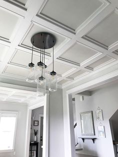 a light fixture hanging from the ceiling in a room with gray walls and white trim