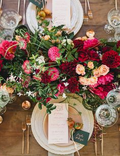 the table is set with flowers and place settings