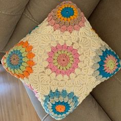 a crocheted pillow sitting on top of a couch