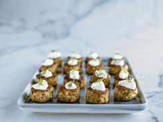 small appetizers are arranged on a plate with sour cream and mint garnishes