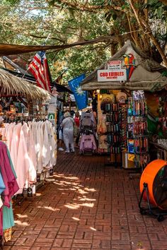 an outdoor market with umbrellas and clothing for sale