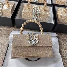 Shaped in a timeless box form, the Anisha Rhinestones Handbag exudes an irresistible allure. However, what truly distinguishes it is its one-of-a-kind handle—a statement piece designed to captivate attention and elevate your ensemble to new heights. With its generous interior, this bag offers ample space for all your essentials, seamlessly blending practicality with undeniable style. Now available in gold and silver. High-end Gold Bag As Gift, Luxury Handheld Evening Bag As Gift, High-end Gold Shoulder Bag As Gift, Crystal Embellished Handheld Evening Bag For Gift, Glamorous Crystal Rectangular Evening Bag, Luxury Top Handle Box Bag For Gift, Luxury Top Handle Box Bag As Gift, Luxury Crystal Clutch As Gift, Luxury Crystal Clutch For Gift