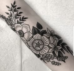 a black and white flower tattoo on the arm