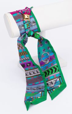 New Hermès Architecture Twilly. The scarf is made out of silk and is multicolor. The print shows different forms and architectural lines. The pieces comes with a scarf ring, the original box and ribbon. Scarf Rings, Twilly, Making Out, New Era, The Original, Original Box, Ribbon, Silk, Architecture