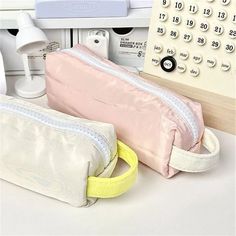 two pink and white bags sitting next to each other on top of a countertop