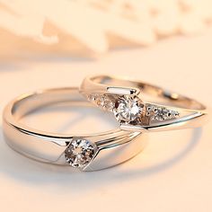 two white gold wedding rings with diamonds on each one and an engagement ring in the other