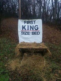 a sign that says first king size bed in front of a pile of hay on the ground